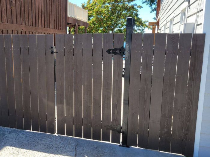 A wooden fence with a metal gate in a garden