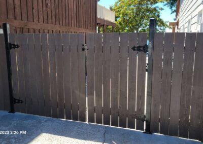 A wooden fence with a metal gate in a garden