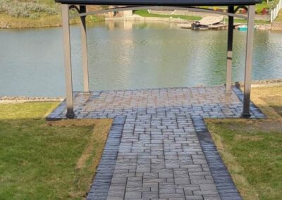 A serene walkway leading to a gazebo by a tranquil lake